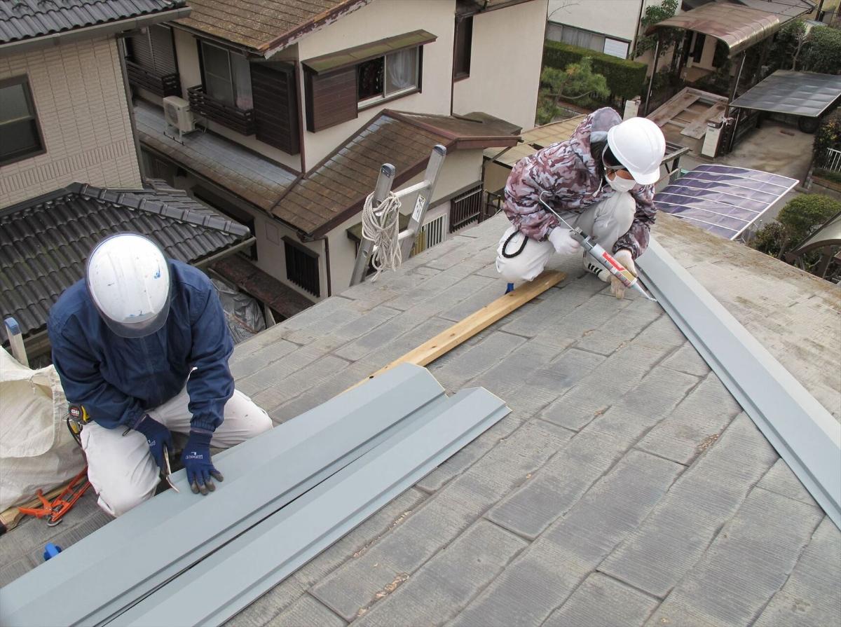 屋根の補修工事を行うスタッフたち